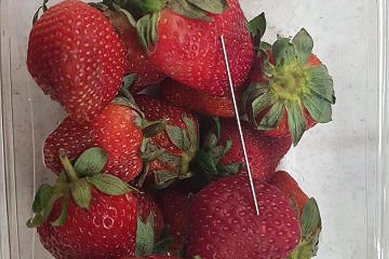 A Queensland police photo showing a thin piece of metal among a basket of strawberries in Gladstone, Queensland.