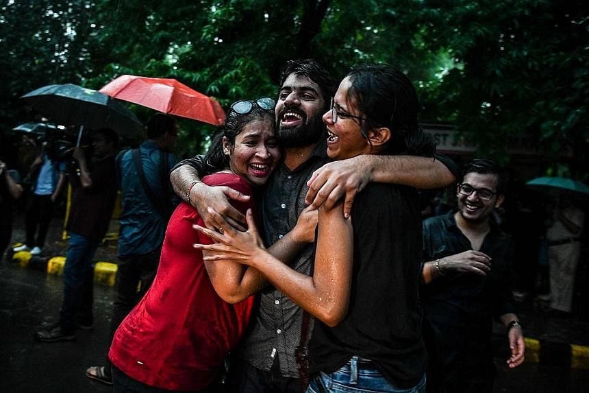 Couple Sunil Mehra (left) and Navtej Singh Johar felt they were finally "equal citizens". Members and supporters of the LGBT community in New Delhi celebrating the decision to strike down the ban on gay sex.