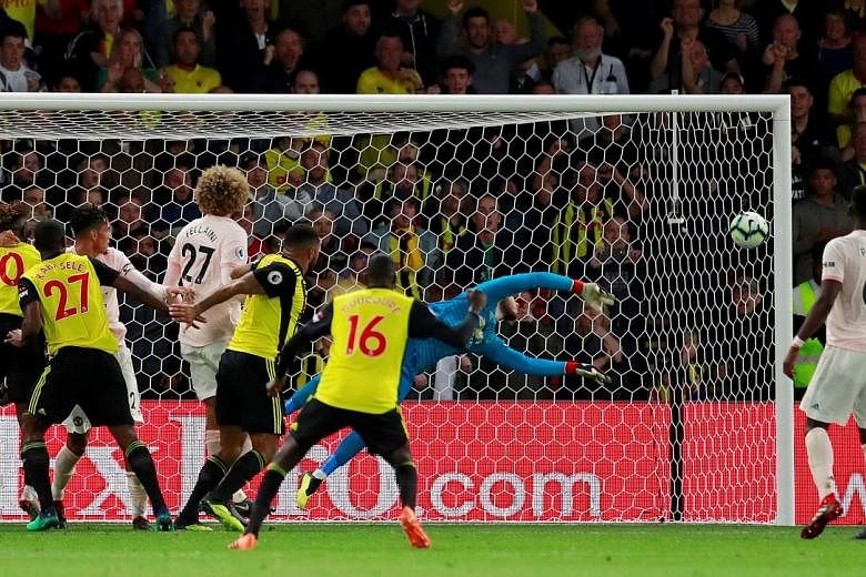 Top: Chris Smalling volleying in United's second goal in the Premier League game against the previously unbeaten Watford at Vicarage Road on Saturday. Above: Goalkeeper David de Gea saving Christian Kabasele's (not in picture) header in stoppage time