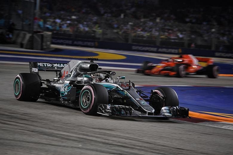 Mercedes' British championship leader Lewis Hamilton leading the pack ahead of German driver Sebastian Vettel (background) of Ferrari after the restart of the Singapore race.