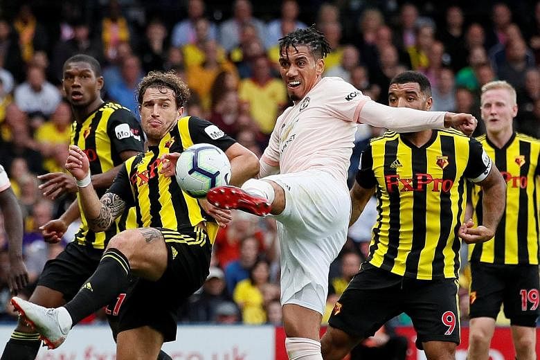 Top: Chris Smalling volleying in United's second goal in the Premier League game against the previously unbeaten Watford at Vicarage Road on Saturday. Above: Goalkeeper David de Gea saving Christian Kabasele's (not in picture) header in stoppage time
