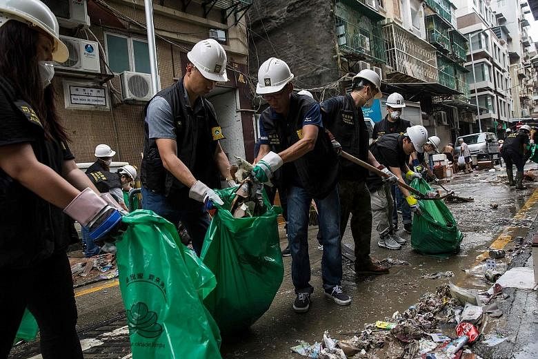 Police officers in Macau clearing rubbish and debris from a street yesterday.