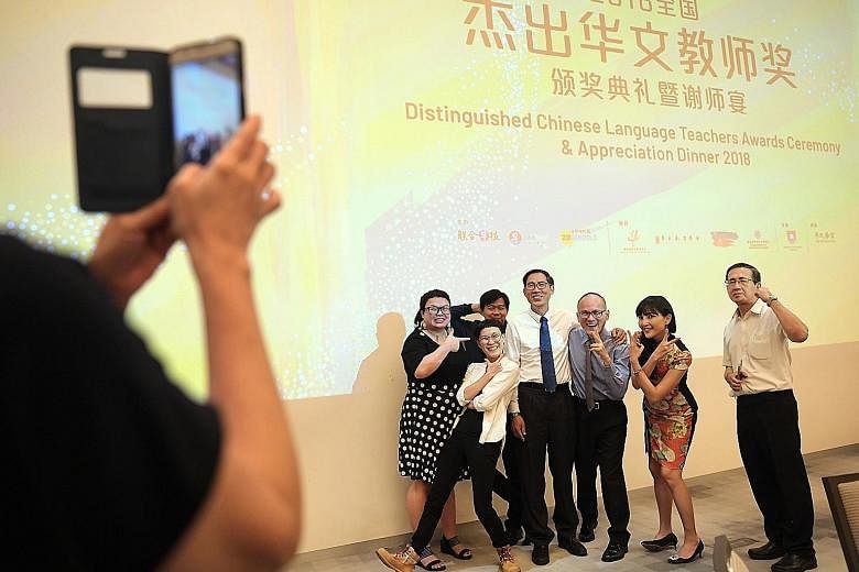 Chinese language teacher Teo Chwee Hock (in grey tie), 56, was one of the 10 teachers recognised at the Distinguished Chinese Language Teachers Awards Ceremony last night. Mr Teo, who has been teaching Chinese for the last 32 years, is seen posing wi