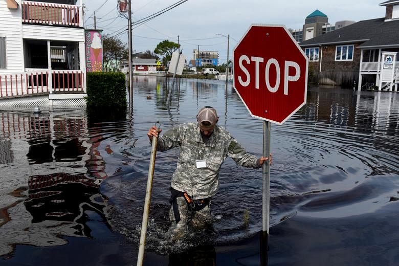 A member of a critical crisis search and rescue team wading through floodwaters in Carolina Beach, North Carolina, on Monday. At least 32 people have been killed since Florence came ashore as a hurricane last Friday. Widespread flooding has reached r