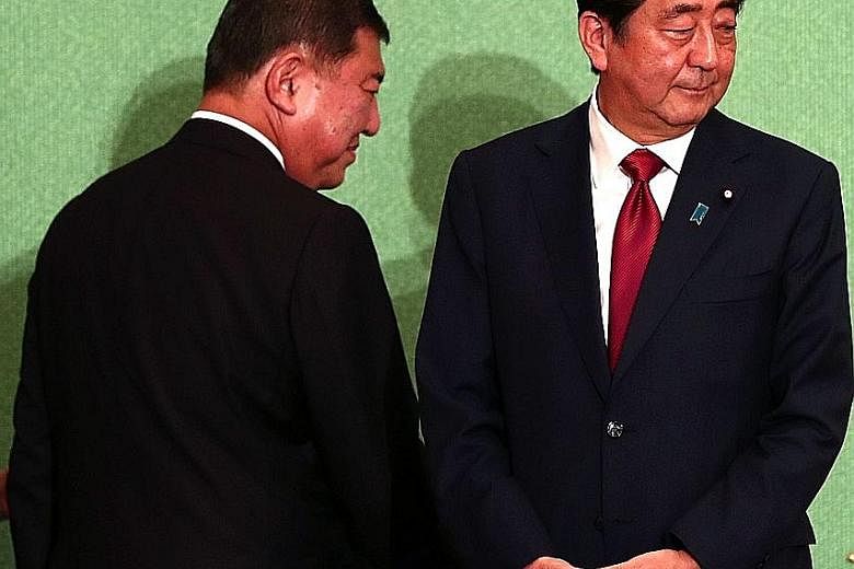 Japan's Prime Minister Shinzo Abe (right) faces former defence minister Shigeru Ishiba (left) in today's election. Mr Abe is seeking more time to amend the pacifist Constitution and pursue economic reforms.