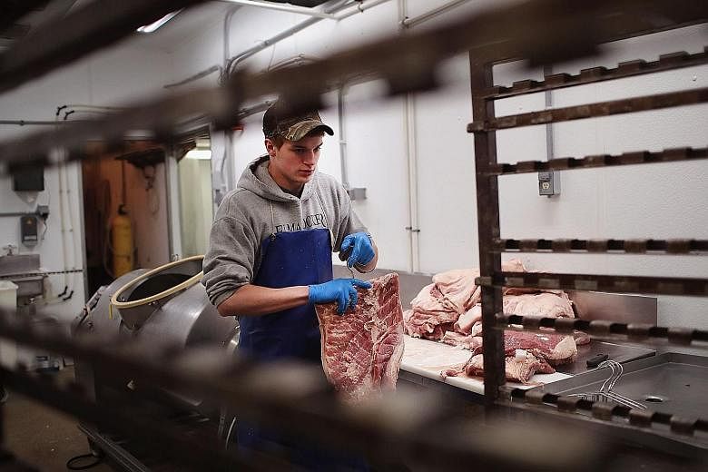 A worker at Elma Locker & Grocery in Iowa, which is the top US state for pork exports. Pork producers in the state are bracing themselves for the impact of a trade war with China.