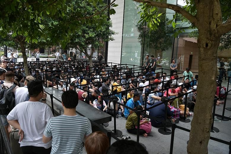 Early birds queueing for the iPhone XS and iPhone XS Max outside the Apple Store in Orchard Road yesterday. The new phones will be launched at 8am today.