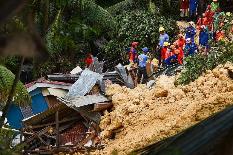 Rescuers searching for survivors at the landslide site in Naga city, on the Philippine tourist island of Cebu yesterday. Days of heavy monsoon rains caused a steep slope of crumbly limestone to collapse and crash into at least 10 homes in the early m