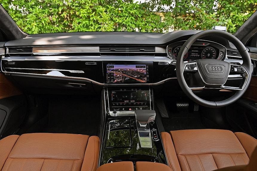 Exquisitely furnished and finished, with open-pore wood veneer and lush leather, the Audi A8 also has black mirror touchscreens on the fascia and a fully digital instrument panel behind the wheel.