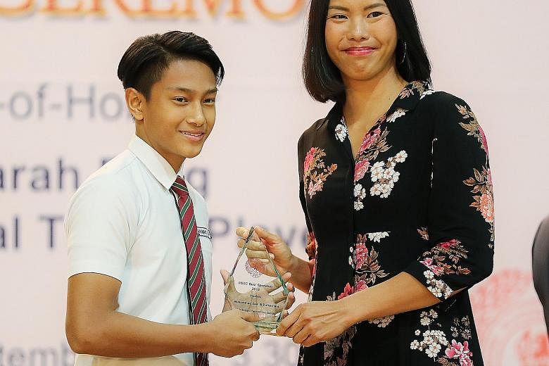 Northland Secondary School's Muhammad Zaki Zulkarnain receiving the Best Schoolboy award (hockey) at yesterday's 48th SSSC Colours Awards from national tennis player Sarah Pang.