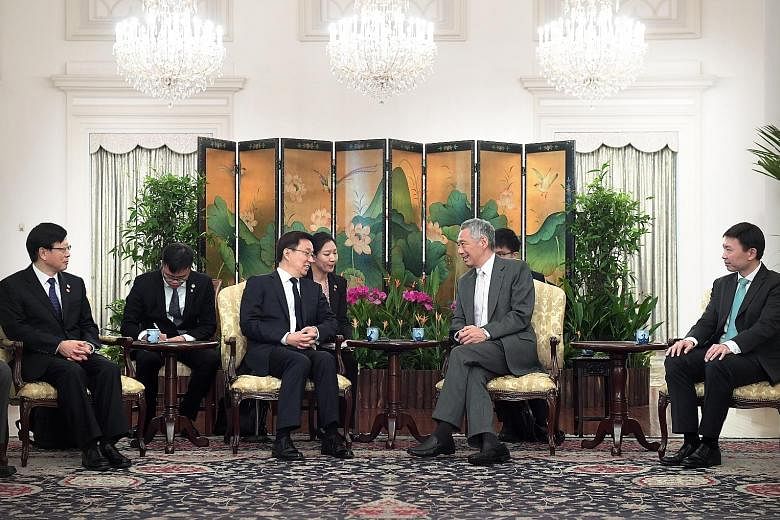 Chinese Vice-Premier Han Zheng meeting President Halimah Yacob (above) and Prime Minister Lee Hsien Loong (right) at the Istana yesterday. The three leaders said they look forward to the conclusion of the China-Singapore Free Trade Agreement negotiat