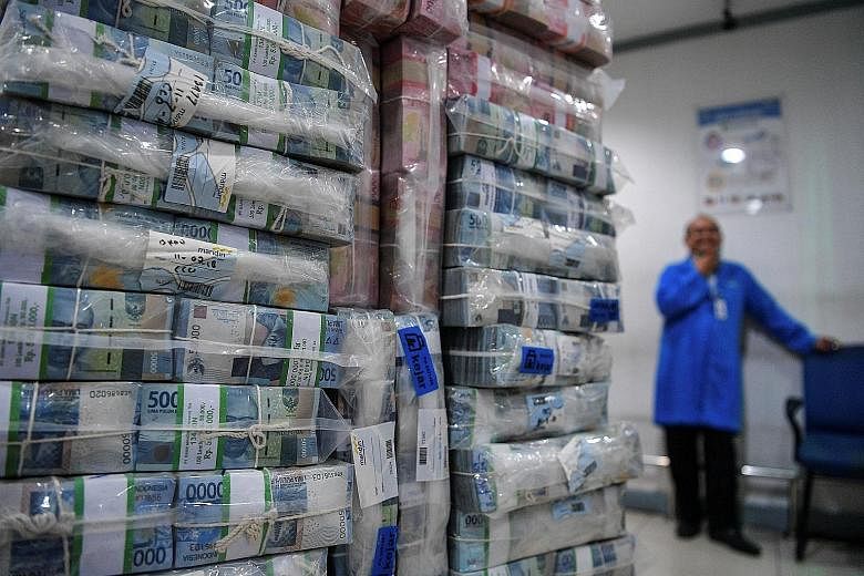 Stacks of Indonesian rupiah banknotes at Bank Mandiri's headquarters in Jakarta. The sharp drop in the currency - caused by a widening current account deficit and further weakened by US-China trade tensions - has prompted Indonesia to consider measur