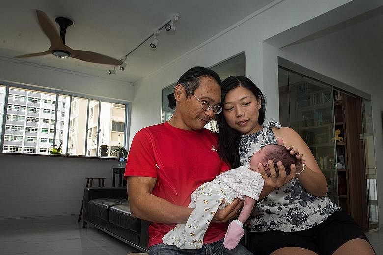 Left: Mr Illyas Lim-Effandi and his wife, Ms Michelle Ng, near their walk-up SIT flat in Tiong Bahru estate. Above: Mr Eric Ho and his wife, Ms See Kwee Hua, with their baby, Hana, in their Holland Drive flat, which has less than 55 years' lease left