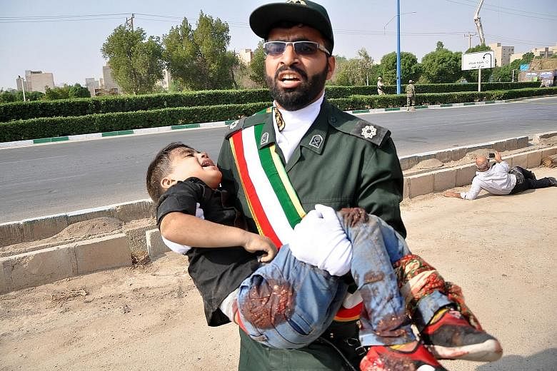 Iranian soldiers and military band members dropping to the ground during the terror attack on a military parade in the city of Ahvaz yesterday. A senior Iranian military spokesman said the attackers had hidden weapons in an area near the parade route