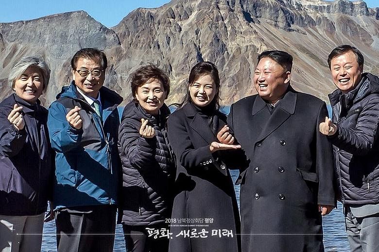 North Korean leader Kim Jong Un (second from right), his wife, Ri Sol Ju (beside him), and South Korean officials making the so-called "finger heart" gesture on top of Mount Paekdu last Thursday. Mr Kim has expressed a willingness to "permanently" sc