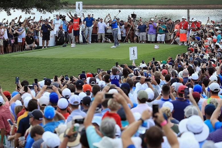 A sea of adoring supporters - and their phones - watch Tiger Woods play his shot from the fourth tee during the third round of the Tour Championship at East Lake Golf Club on Saturday.