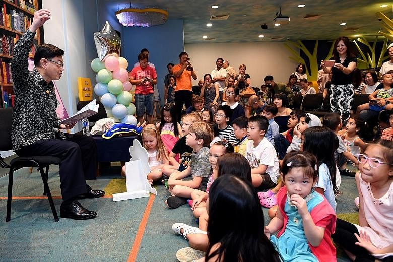 Finance Minister Heng Swee Keat reading to children about the life of Singaporean scientist Chou Loke Ming at the launch of the Asian Scientist Junior Book Series, a children's book series featuring six scientists from Asia.