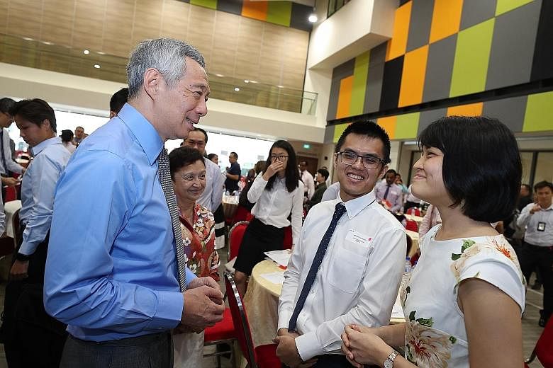 Prime Minister Lee Hsien Loong interacting with two new Singapore citizens - Mr Wong Songhan and his wife, Ms Pang Sheau Shiuh - at yesterday's citizenship ceremony in Teck Ghee Community Club. Mr Lee urged the 150 new citizens to be active citizens 