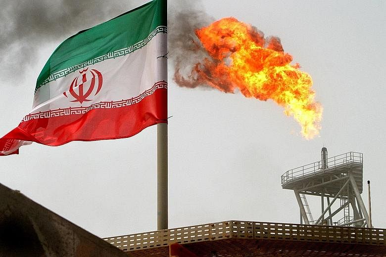 The Iranian flag flying on an oil production platform in the Soroush oil fields in the Persian Gulf. Commodity traders Trafigura and Mercuria yesterday said Brent could pass US$100 early next year, as markets tighten once US sanctions against Iran ar