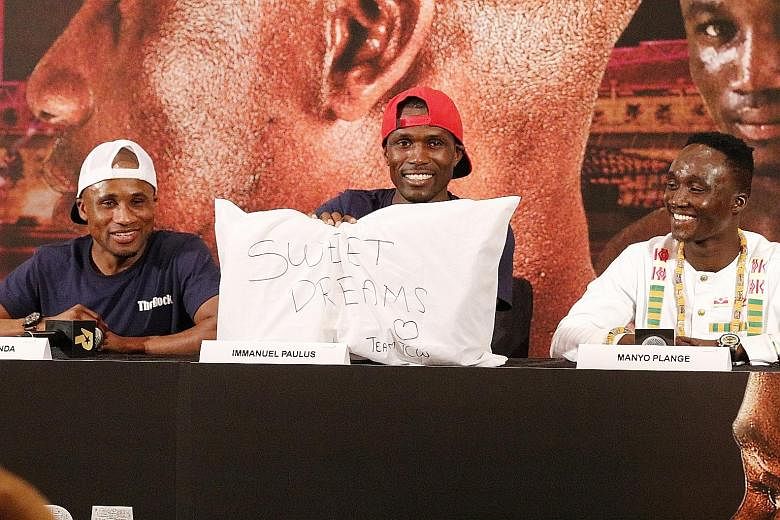 Above: Immanuel Paulus, the trainer of Namibian boxer Paulus Ambunda, holding up the pillow gift. Left: Muhamad Ridhwan and veteran Ambunda facing off after the press conference for the Roar of Singapore V: Kings of the Lion City event.