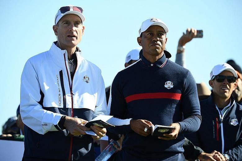 Tiger Woods speaking with US Ryder Cup team captain Jim Furyk during a practice session at Le Golf National Course, south-west of Paris yesterday. The biennial tournament against Europe starts on Friday.