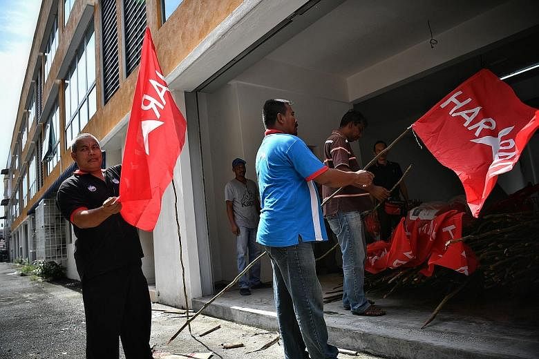 Above: Parti Keadilan Rakyat supporters preparing the command centre for the Oct 13 by-election in Port Dickson. Left: Residents of Port Dicksonare hoping Datuk Seri Anwar Ibrahim's expected return to Parliament will usher in a new period of growth a