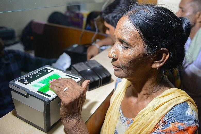 A woman getting her fingerprints read while registering for Aadhaar, which has provided biometric identities to over a billion people.