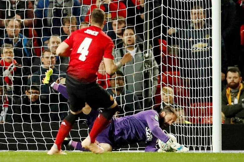 Left: Manchester United defender Phil Jones sees his penalty saved by Derby County goalkeeper Scott Carson in the home side's 8-7 shoot-out defeat on Tuesday. United manager Jose Mourinho claimed later that he knew that Jones was unlikely to score. B