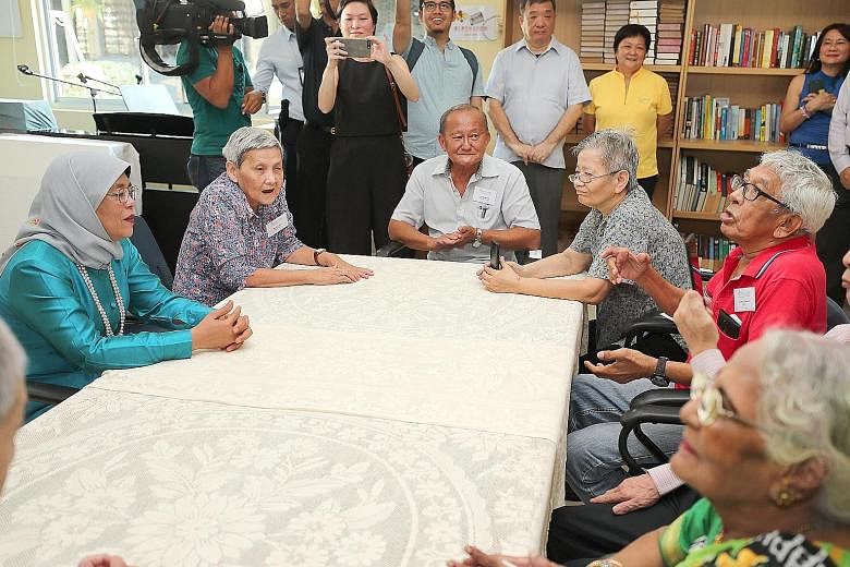 President Halimah Yacob chatting with St John's Home resident Tan Sing Choon, 93, and volunteer Anita Lin (left, in blue), 72, yesterday. Accompanying the President are Potong Pasir MP Sitoh Yi Pin (behind Madam Lin) and Mr Woon Wee Yim, the home's c