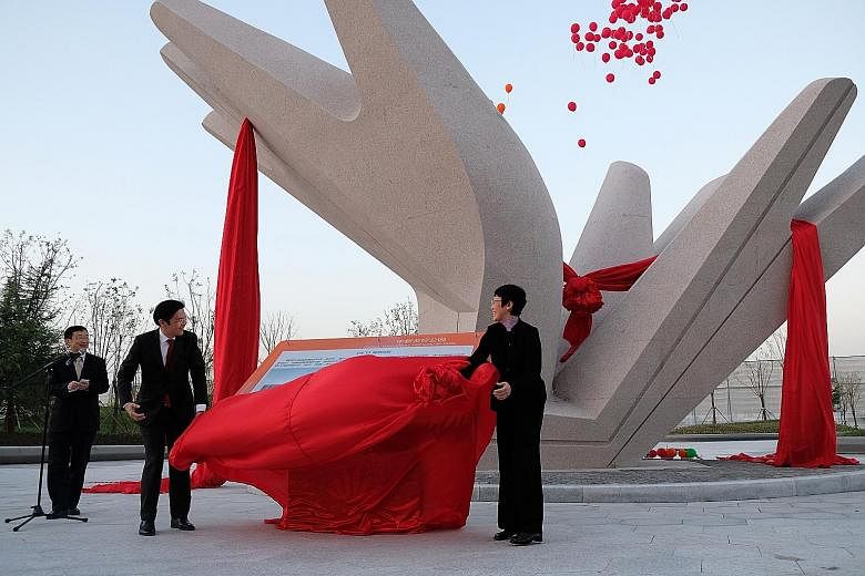 National Development Minister Lawrence Wong and China's Vice-Minister of the Ministry of Housing and Urban-Rural Development, Ms Huang Yan, unveiling a sculpture outside the China-Singapore Friendship Library to commemorate the Tianjin Eco-city's 10t