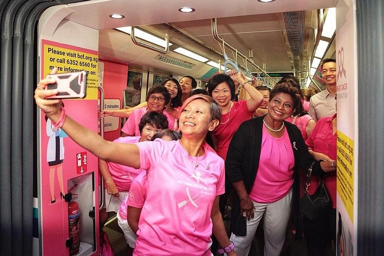 Breast Cancer Foundation's (BCF) Paddlers in Pink dragon-boat members, with Senior Minister of State Sim Ann (centre) and BCF president Noor Quek (in black cardigan), taking a wefie at the launch of the Pink Train yesterday. The train features the me