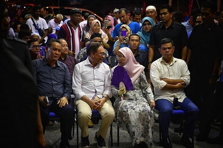 Datuk Seri Anwar Ibrahim with his wife, Deputy Prime Minister Wan Azizah Wan Ismail, and Parti Keadilan Rakyat officials at the party's election centre in Port Dickson. Mr Mohd Saiful Bukhari Azlan, a former aide to Mr Anwar who had accused him of so