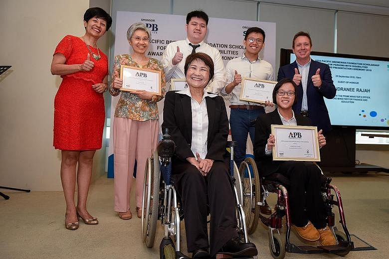 At yesterday's event are (back row from left) Ms Indranee Rajah, Minister in the Prime Minister's Office; Mrs Lee Sok Fun, mother of scholarship recipient Lionel Lee (not present at the ceremony); Mr Caleb Tay; Mr Justin Kueh; APB Singapore managing 