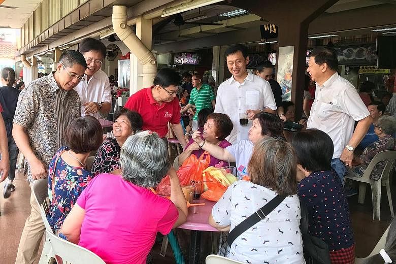 (Standing, from far left) Senior Minister of State Maliki Osman, Ang Mo Kio GRC MP Gan Thiam Poh, Finance Minister Heng Swee Keat and Education Minister Ong Ye Kung talking to residents at Hougang Village, which is part of Sengkang South division, du