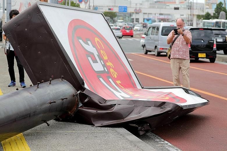 A collapsed restaurant signboard in the city of Urasoe on the southern island of Okinawa. Nearly 500,000 households in the south-western region of Kyushu and Okinawa have lost power after Typhoon Trami hit the area.