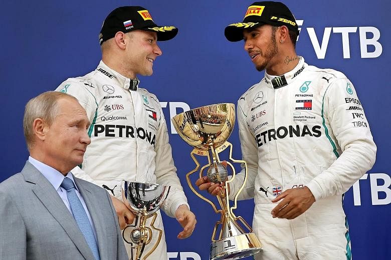 Lewis Hamilton with teammate Valtteri Bottas after getting him onto the podium's top step, as Russian President Vladimir Putin watches.