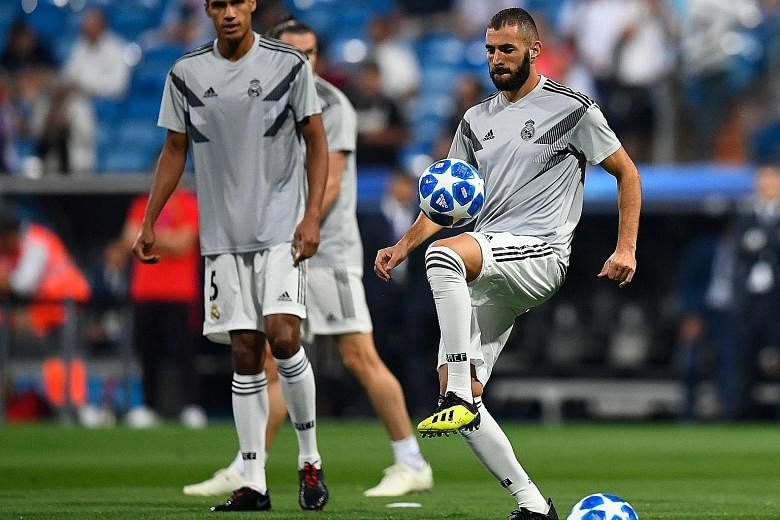 Real Madrid defender Raphael Varane and forward Karim Benzema warming up before their Champions League opener against Roma in Madrid last month. While Varane is set to keep his spot, Benzema's five-game dry spell means he may be replaced by new boy M