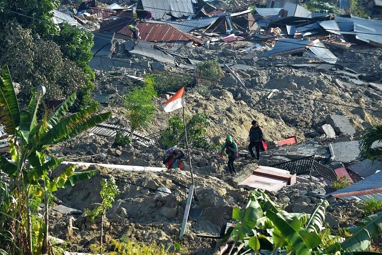 An Indonesian flag fluttering in the midst of damaged homes in Palu, Central Sulawesi, yesterday. The province was hit by a magnitude-6.1 earthquake last Friday afternoon, before a stronger magnitude-7.4 temblor struck, triggering a 7m-high tsunami w