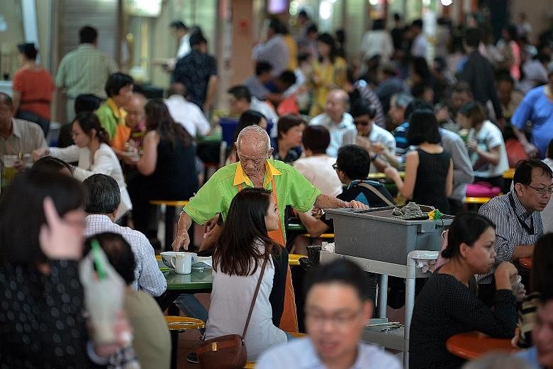 Cleaners at the Maxwell Food Centre. Under the new law, over 40,000 Singaporean and permanent resident cleaners may receive up to 4 per cent more in wages each year.