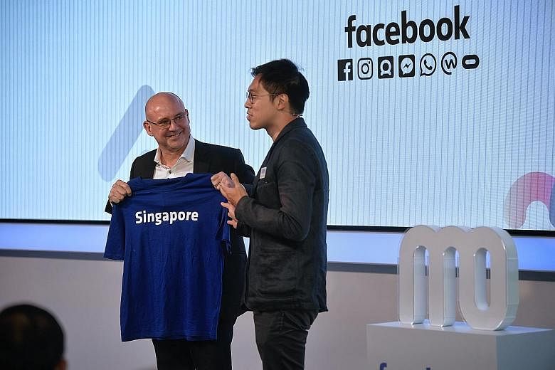 Above: Facebook's vice-president of Asia-Pacific Dan Neary receiving a T-shirt from Economic Development Board managing director Chng Kai Fong at the opening of Facebook's new office yesterday. Left: Facebook staff at their new office, which is locat