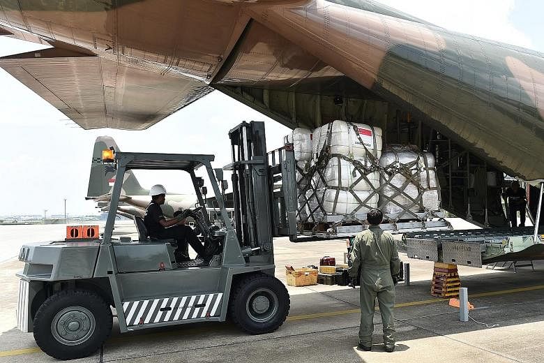 Humanitarian aid supplies being loaded onto a C-130 transport aircraft at Paya Lebar Airbase. Defence Minister Ng Eng Hen said both C-130 aircraft will remain in Sulawesi to transport survivors to other Indonesian cities, as requested by the Indonesi