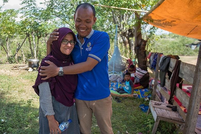 Mr Azwan with his wife Dewi in front of their home and family members in Palu, Central Sulawesi, on Monday, after an earthquake and tsunami hit the area last Friday. He spent two agonising days searching through makeshift morgues and hospitals before