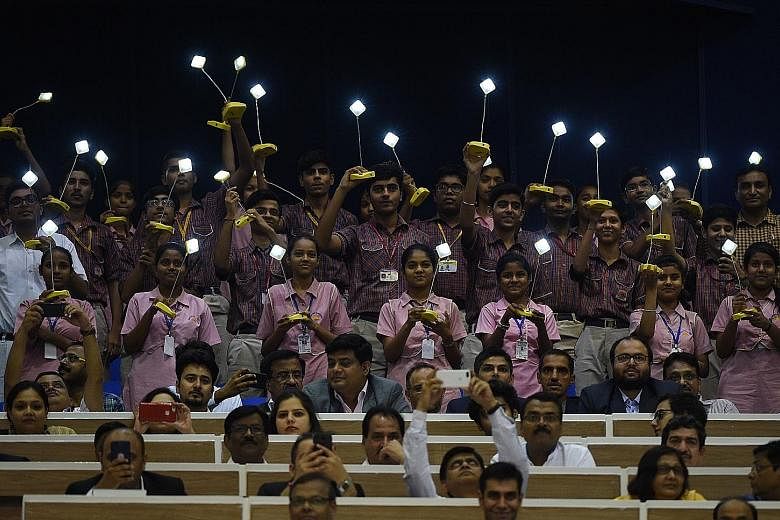 Indian schoolchildren with solar lamps during a renewable energy expo in New Delhi on Tuesday.