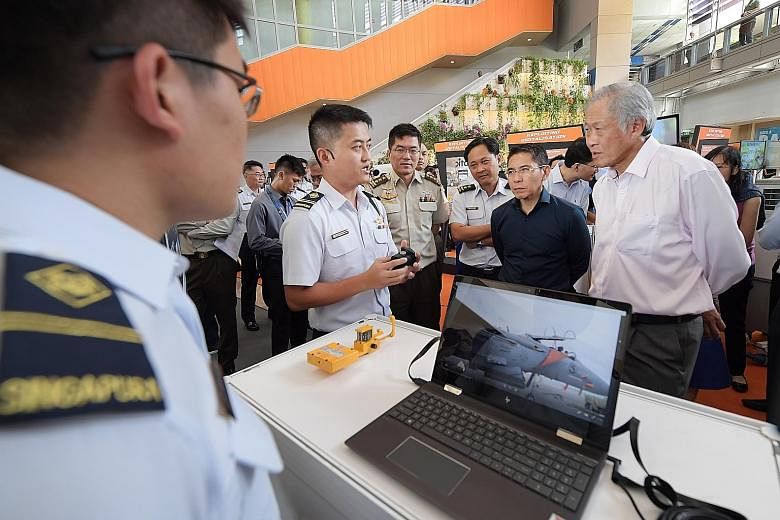 Military Expert 4 Sebastian Zheng briefing Defence Minister Ng Eng Hen on his team's project, which allows the Republic of Singapore Air Force to calibrate its navigation compass for the F-15SG aircraft without the need for a certified physical compa
