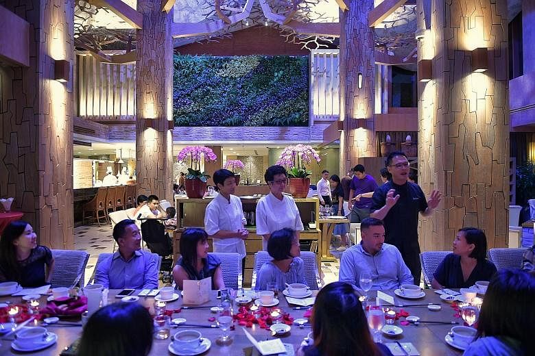 Chef Sam Leong (standing, right) with ST readers at his restaurant Forest, as they are treated to a meal created by him, his mother, Madam Pit Yoke Eng (standing, centre), his wife, Forest (standing, left), and his son, Joe.