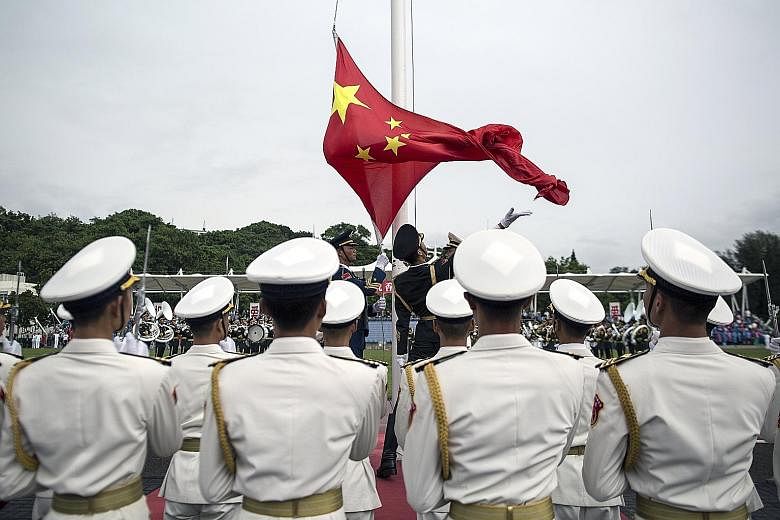 A flag-raising ceremony at a Hong Kong naval base last year. Djibouti is the opening chapter to a greater Chinese military presence overseas, says the writer. Now that China has gathered the experience and know-how, Beijing sources say it is only a m