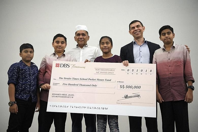 Mini Environment Service Group founder and chief executive Mohamed Abdul Jaleel (in white) with his grandchildren (from left) Mohamed Ayman, 11; Mohamed Shayaan, 11; Ayana, 11; and Mohamed Rayhan, 12, as he presented the fund's chairman, Mr Warren Fe