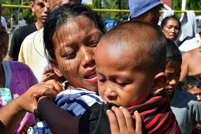 Indonesian military personnel unloading supplies from a Singapore military plane at Mutiara Al Jufri Airport in Palu yesterday. Ms Susi Rahmatia in an emotional reunion with her five-year-old son Jumadil yesterday, after he went missing for seven day