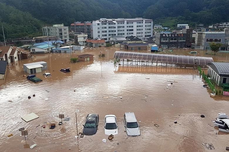 Buildings, cars and roads flooded yesterday by torrential rains brought by Typhoon Kong-rey in Yeongdeok, South Korea.