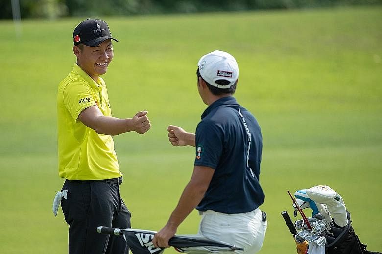 A good shot by Chinese golfer Lin Yuxin during his round of 62 is acknowledged by flight-mate Takumi Kanaya.